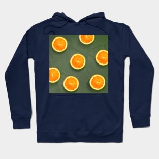 Oranges slices pattern background, fresh fruits on green background Hoodie